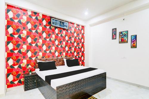 a bedroom with a bed with a colorful wall at Hotel O Serene Inn Hotel And Restaurant in Lucknow