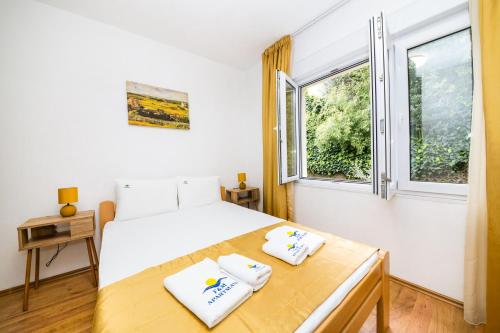 a bedroom with a white bed and a window at Apartmani F&M in Kotor