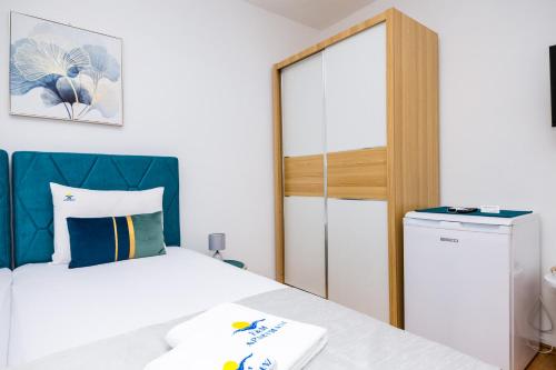 a bedroom with a bed and a washer and dryer at Apartmani F&M in Kotor