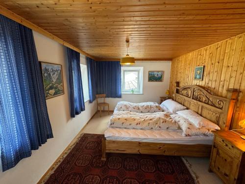 a bedroom with a bed and a wooden ceiling at Blusnerhof in Virgen