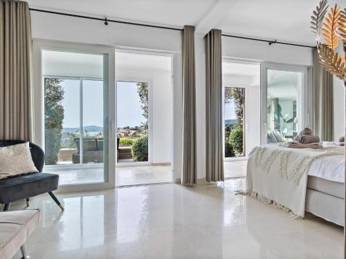 - une chambre avec un lit et des portes coulissantes en verre dans l'établissement Golf dOr C6, à Sainte-Maxime