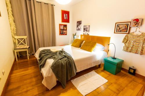 a bedroom with a large white bed and wooden floors at epicenter SKYBAR in Lagoa