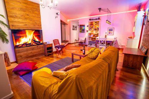 a living room with a yellow couch and a fireplace at epicenter SKYBAR in Lagoa