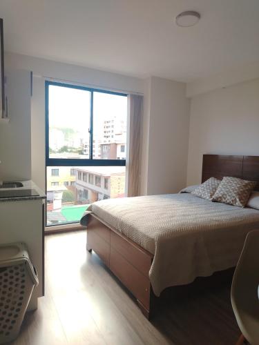 a bedroom with a bed and a large window at Mono Samay 216 in Cochabamba