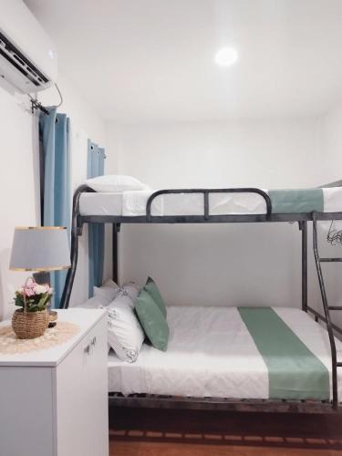 a bedroom with two bunk beds and a table with a lamp at De Richness in Tagbilaran City