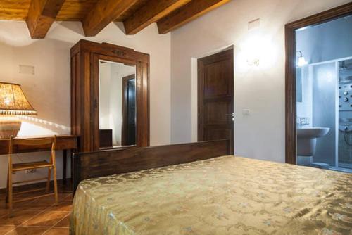 a bedroom with a bed and a desk and a mirror at Agriturismo Miracco Atanasio Franco "Il Maniero" in Santa Sofia dʼEpiro