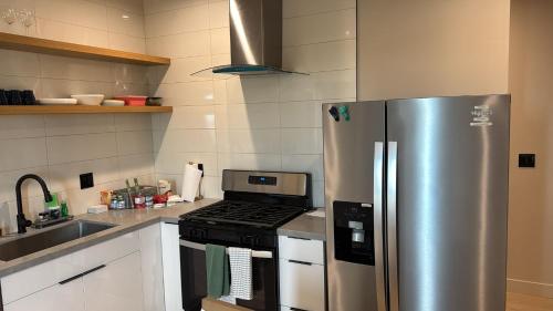 a kitchen with a stainless steel refrigerator and a stove at Stylish Urban Escape in Downtown Los Angeles in Los Angeles