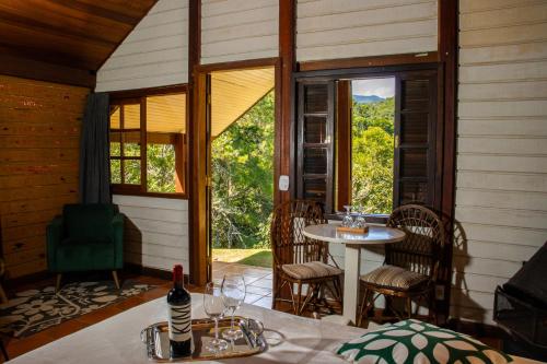 a room with a table and chairs and a window at Pousada Olivier da Montanha - Recanto das Águas in Santo Antônio do Pinhal