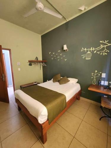 a bedroom with a bed with a green wall at Hotel Plaza Queretaro in Querétaro