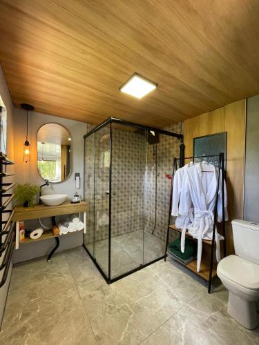 a bathroom with a shower and a toilet and a sink at Vale Dos Pinheiros in Rio Forcação