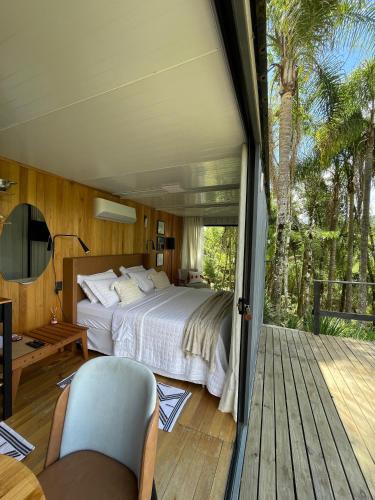 a bedroom with a large bed and a deck at Vale Dos Pinheiros in Rio Forcação