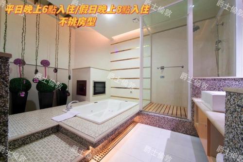 a bathroom with a tub and a sink at AmanCity Motel in Pingtung City