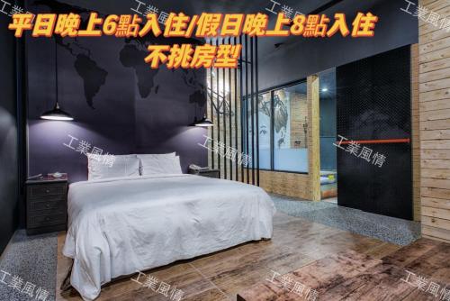 a bedroom with a large white bed and a black wall at AmanCity Motel in Pingtung City