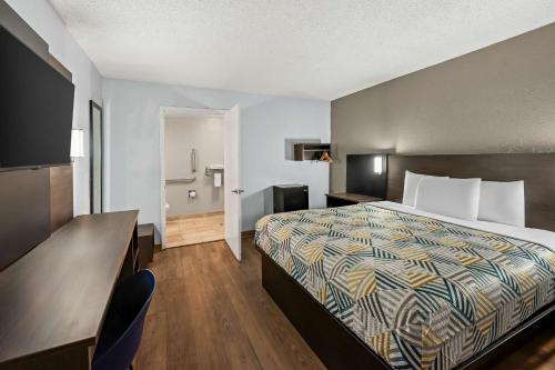 a hotel room with a bed and a bathroom at Motel 6 Lester - Philadelphia Airport in Lester