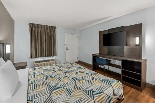 a hotel room with a bed and a flat screen tv at Motel 6 Lester - Philadelphia Airport in Lester