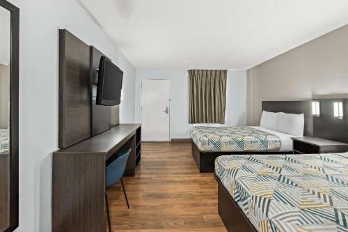 a hotel room with two beds and a flat screen tv at Motel 6 Lester - Philadelphia Airport in Lester