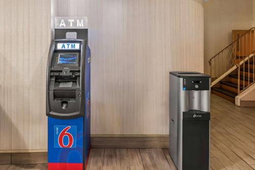 a atm machine in a room with a staircase at Motel 6 Lester - Philadelphia Airport in Lester