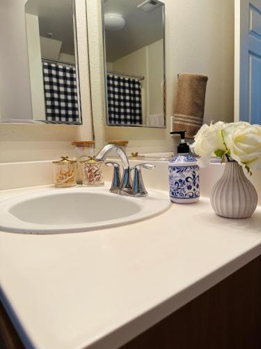 a bathroom sink with a vase of flowers and a mirror at Loft Style,2 Beds ,Flexible self check in,Pool in Marina del Rey