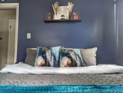 um travesseiro em uma cama com uma parede roxa em Stylish & Cozy #1 8 mins to DCA & Washington DC em Alexandria