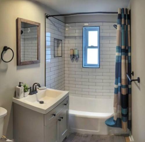 um banheiro com pia, banheira e chuveiro em Stylish & Cozy #1 8 mins to DCA & Washington DC em Alexandria