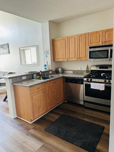 a kitchen with wooden cabinets and a stove top oven at Loft Style,2 Beds ,Flexible self check in,Pool in Marina del Rey