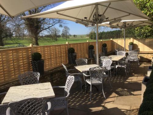 a patio with tables and chairs under an umbrella at The Brownlow Arms Inn in Grantham