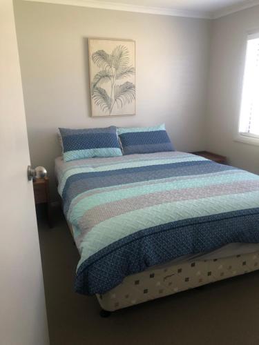 a bedroom with a bed with blue pillows at Home in wodonga-Comfort city in Wodonga