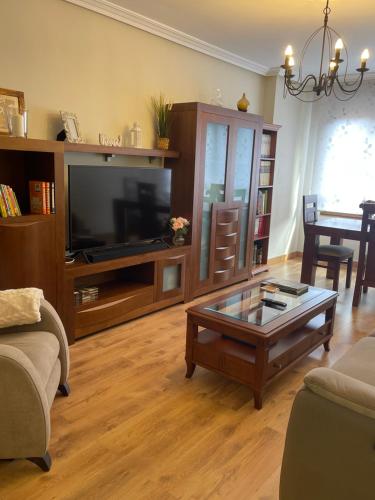 a living room with a tv and a coffee table at Casa Pilar Casa Llara, En el paraíso, cerca de todo in Ujo