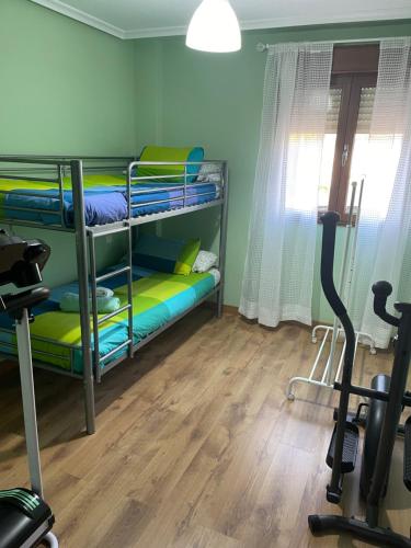a room with bunk beds and a treadmill at Casa Pilar Casa Llara, En el paraíso, cerca de todo in Ujo