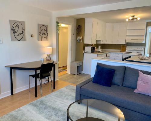 Una sala de estar con un sofá azul y una cocina. en Central Location Cozy and Well-Equipped, Unit #3, en Halifax