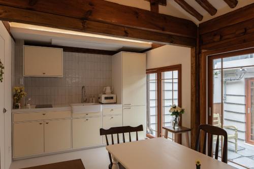 a kitchen with white cabinets and a table at Sabrina at Hanok in Seoul