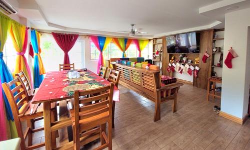 a dining room with a table and chairs and curtains at Popoyo Beach Home in Tola