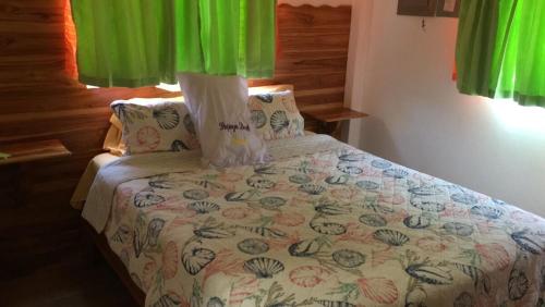 a bed in a bedroom with green curtains at Popoyo Beach Home in Tola