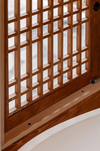 a window with a wooden frame on top of a bed at Sabrina at Hanok in Seoul
