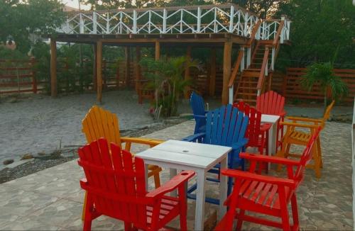 a group of colorful chairs and a table in a yard at Popoyo Beach Home in Tola