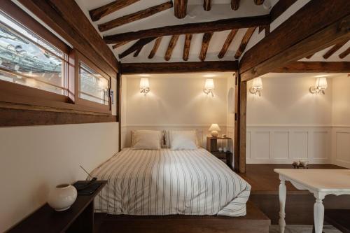 a bedroom with a bed and a desk and a window at Sabrina at Hanok in Seoul