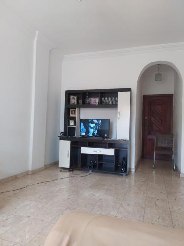 ein Wohnzimmer mit einem Flachbild-TV auf einem Stand in der Unterkunft Centro - Perto de tudo in Salvador