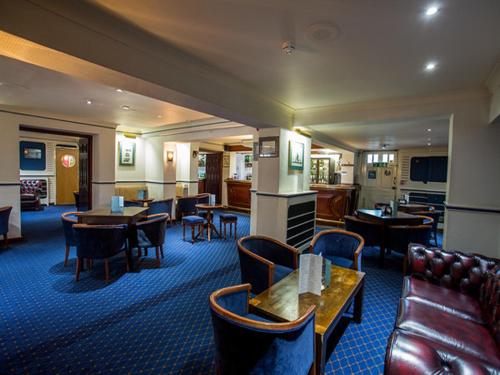 a hotel room with tables and chairs and a couch at The Clarendon Hotel in London