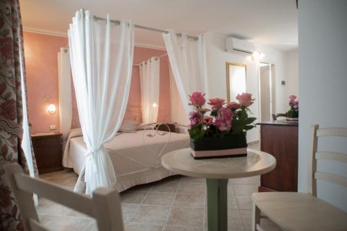 a bedroom with a bed and a table with flowers on it at B&B Corte dell' Immacolata in Taviano