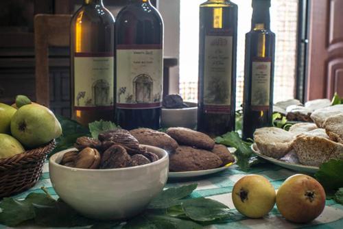 a table topped with plates of food and bottles of wine at Agriturismo Miracco Atanasio Franco "Il Maniero" in Santa Sofia dʼEpiro