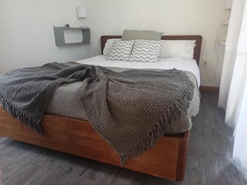 ein Bett mit einer Decke und Kissen darauf in der Unterkunft Mucho cielo y mucho mar in Punta Colorada