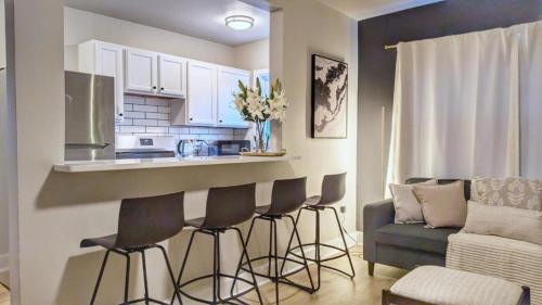 a kitchen with a bar with chairs and a couch at Stylish & Cozy #3 8 mins to DCA & Washington DC in Alexandria