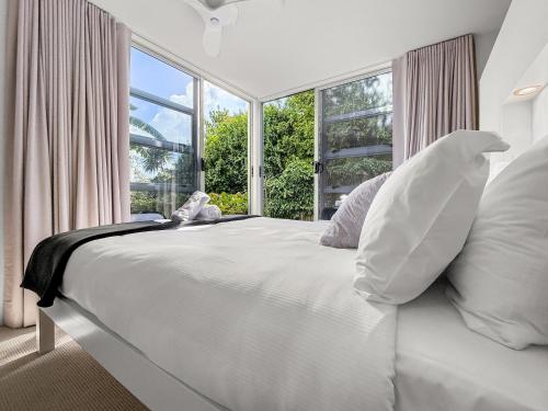 a white bed in a room with a large window at Westmere Wonder l Gorgeous 3 Bed Home inc View in Auckland