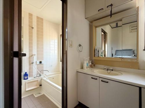 bagno con lavandino, vasca e specchio di 民宿 中部国际机场 常滑站 a Tokoname