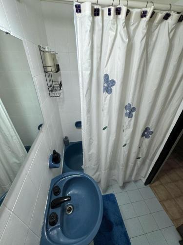 a bathroom with a blue sink and a shower curtain at CasaSansaba in Gerli