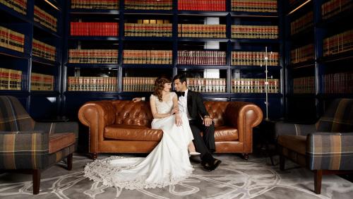 a bride and groom sitting on a leather couch at Kimpton Gray Hotel Chicago by IHG in Chicago