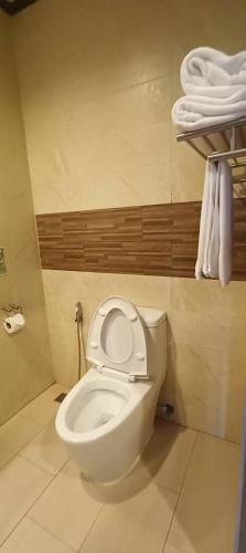 a white toilet in a bathroom with towels at โรงแรมชาวเกาะพีพี Chaokoh Phi Phi Island in Phi Phi Don