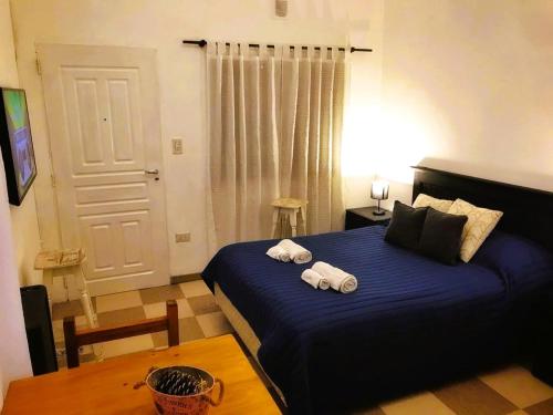 a bedroom with a blue bed with towels on it at MG Suites in Monte Grande