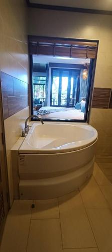 a bath tub with a window in a bathroom at โรงแรมชาวเกาะพีพี Chaokoh Phi Phi Island in Phi Phi Don
