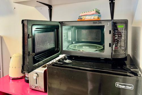 a microwave oven sitting on top of a appliance at Micro Studio Apartment in University District- 10 mins walk to University of WA in Seattle